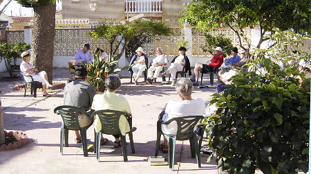 Foto de un grupo en discussion en el jardin del albergue